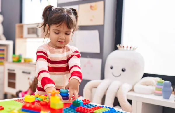 stock image Adorable hispanic girl playing with construction blocks standing at kindergarten