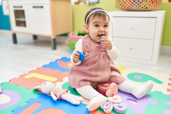 Liebenswertes Hispanisches Baby Sitzt Kindergarten Auf Dem Boden Und Lutscht — Stockfoto