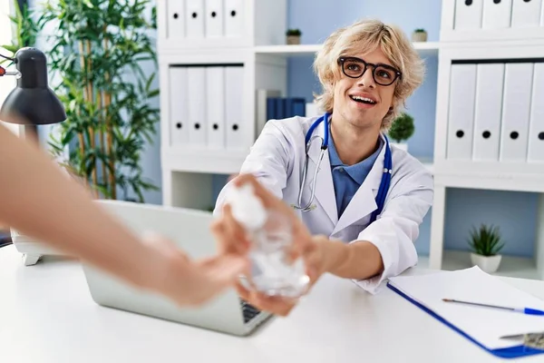 Young Blond Man Doctor Smiling Confident Using Sanitizer Gel Hands — Stock Photo, Image