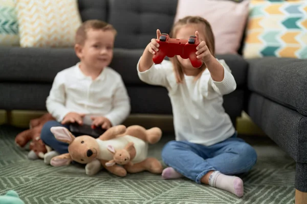 可爱的男孩和女孩坐在家里的地板上玩游戏 — 图库照片