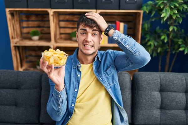 Ung Latinamerikansk Man Som Håller Potatischips Stressad Och Frustrerad Med — Stockfoto