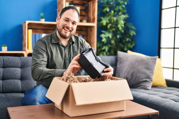 Young Hispanic Man Unpacking Virtual Reality Glasses Sitting Sofa Home — Foto Stock