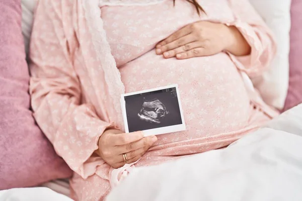 Молодая Беременная Женщина Трогает Живот Держа Экографию Спальне — стоковое фото