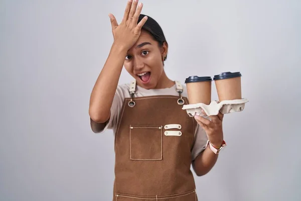 Young Hispanic Woman Wearing Professional Waitress Apron Holding Coffee Surprised — Zdjęcie stockowe