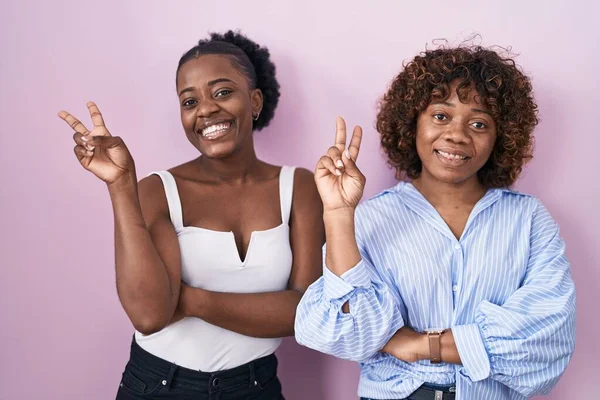 Two African Women Standing Pink Background Smiling Happy Face Winking — Stok fotoğraf