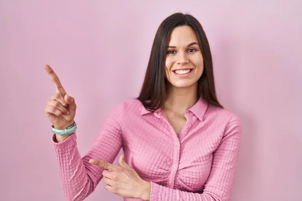 Young Hispanic Woman Standing Pink Background Smiling Looking Camera Pointing — Foto de Stock