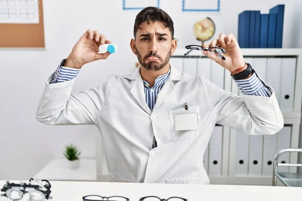 Young Optician Man Holding Glasses Contact Lenses Depressed Worry Distress — Stock Photo, Image