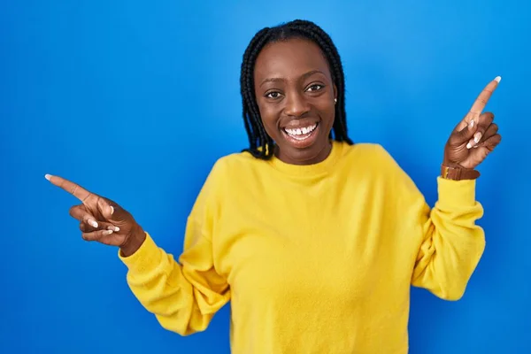 Mooie Zwarte Vrouw Staat Blauwe Achtergrond Glimlachend Zelfverzekerd Wijzend Met — Stockfoto