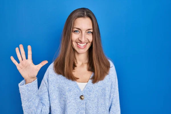 Young Woman Standing Blue Background Showing Pointing Fingers Number Five — Stock Photo, Image
