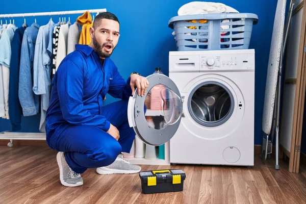Hispanic Repairman Working Washing Machine Scared Amazed Open Mouth Surprise — Stockfoto