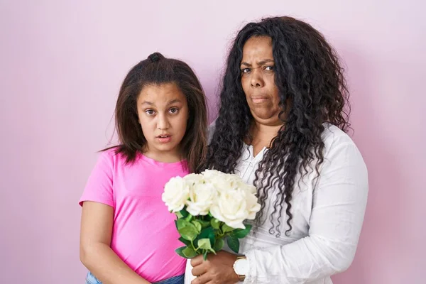 母と若い娘ショック顔に白い花の花束を保持 懐疑的で皮肉を探して オープン口で驚いて — ストック写真