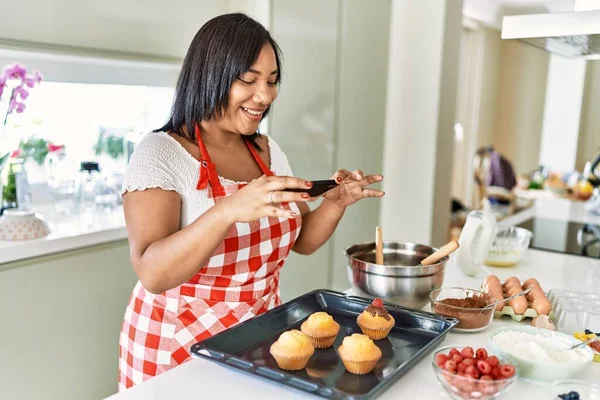 Hispanic Brunette Woman Taking Photo Chocolate Muffins Kitchen — Zdjęcie stockowe