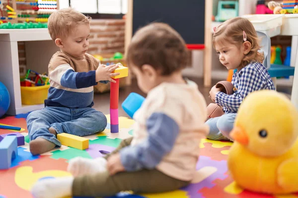 幼稚園の床に座っておもちゃで遊んでいる子供たちのグループ — ストック写真