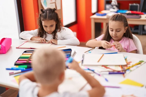 一群学龄前儿童坐在桌子上 在教室里画着纸 — 图库照片