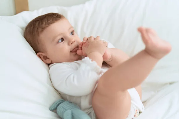 Liebenswertes Kleinkind Liegt Auf Bett Und Lutscht Füße Schlafzimmer — Stockfoto