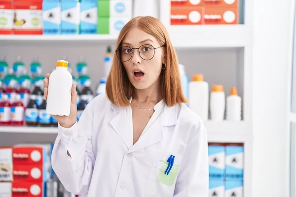 Young Redhead Woman Working Pharmacy Drugstore Holding Sun Screen Scared — Foto Stock