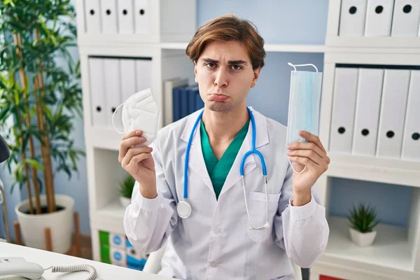 Young Doctor Man Holding Two Safety Mask Depressed Worry Distress — Stock Photo, Image