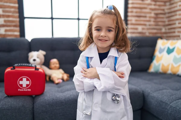 Urocza Latynoska Dziewczyna Mundurze Lekarza Stojąca Rękami Skrzyżowanymi Domu — Zdjęcie stockowe