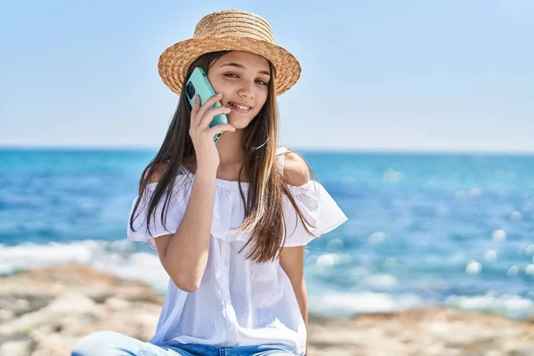Adorable girl tourist smiling confident talking on the smartphone at seaside