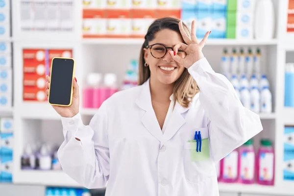 Femme Blonde Travaillant Pharmacie Drugstore Montrant Écran Smartphone Souriant Heureux — Photo