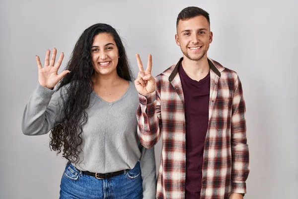 Young Hispanic Couple Standing White Background Showing Pointing Fingers Number — Stock Photo, Image