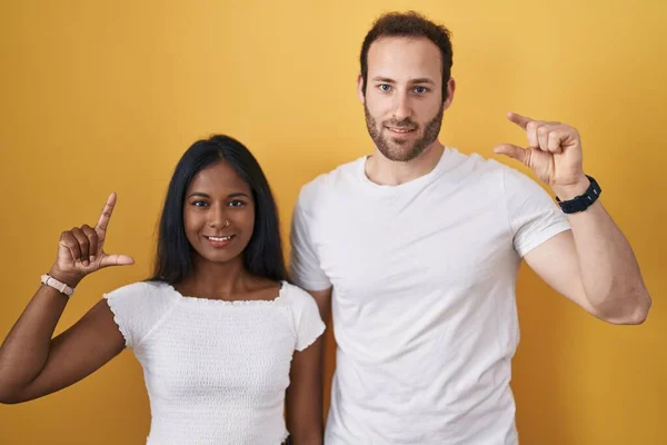 Interracial Couple Standing Yellow Background Smiling Confident Gesturing Hand Doing — Foto Stock
