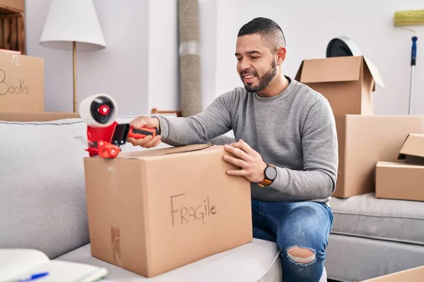 Jonge Latijnse Man Glimlachend Zelfverzekerd Verpakking Kartonnen Doos Nieuw Huis — Stockfoto