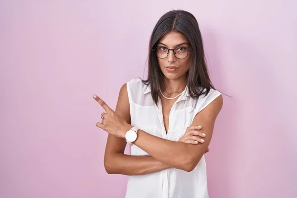 Brunette Young Woman Standing Pink Background Wearing Glasses Pointing Hand — Stock fotografie