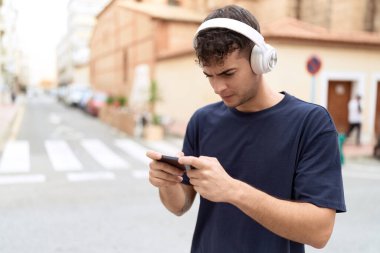 Sokakta video oyunu oynayan genç bir İspanyol.