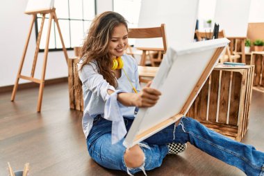 Güzel İspanyol kadın sanatçı gülümsüyor. Sanat stüdyosunda kendine güveni tam görünüyor.