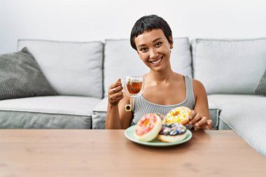 Genç İspanyol kadın evde kahvaltı ederken kendine güler yüzlü.