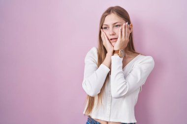 Pembe arka planda duran beyaz bir kadın. Yorgun eller, yüzü, depresyonu ve üzüntüyü örten, sorun yüzünden üzgün ve tedirgin. 