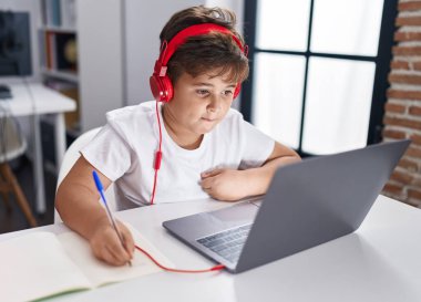 Sevimli İspanyol öğrenci sınıfta dizüstü bilgisayar kullanıyor.
