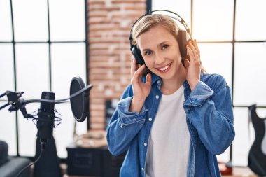 Müzik stüdyosunda kendine güvenen genç sarışın müzisyen.