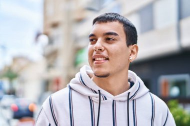 Sokakta kendine güvenen genç adam gülümsüyor