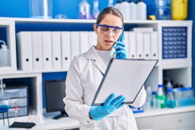 Laboratuardaki akıllı telefon okuma dokümanında konuşan genç bilim kadını.