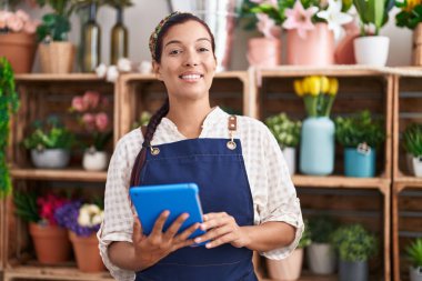 Çiçekçiye dokunarak gülen güzel İspanyol kadın çiçekçi.