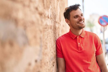 Sokakta kendinden emin gülümseyen İspanyol genç adam.
