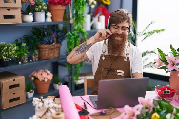 Young Redhead Man Florist Using Headset Laptop Working Flower Shop —  Fotos de Stock