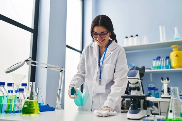 Young Hispanic Woman Wearing Scientist Uniform Cleaning Using Sanitizer Gel — Stok fotoğraf