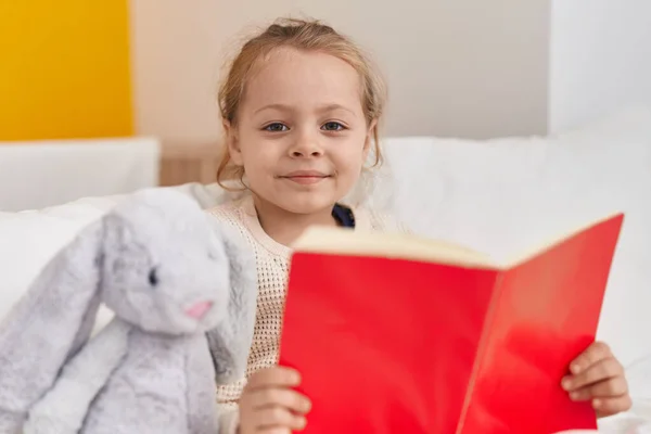 Adorable Blonde Girl Reading Book Sitting Bed Bedroom — Stockfoto