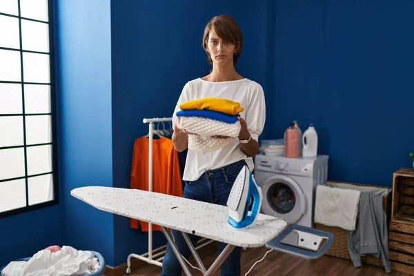 Brunett Kvinna Håller Vikt Tvätt Efter Strykning Skeptisk Och Nervös — Stockfoto