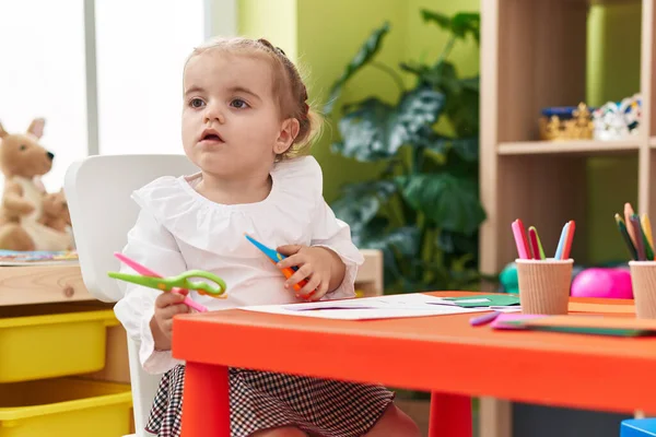 Anaokulunda Elinde Makasla Masada Oturan Sevimli Sarışın Çocuk — Stok fotoğraf