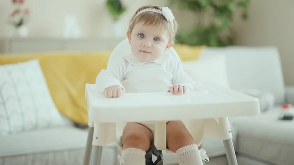 可爱的金发碧眼的婴儿自信地坐在家里的高椅子上 — 图库照片