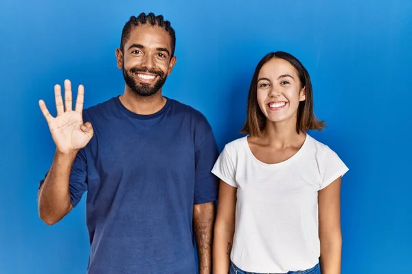 Young Hispanic Couple Standing Together Showing Pointing Fingers Number Four — Fotografia de Stock