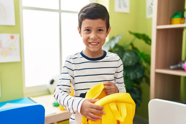 Uroczy Latynoski Chłopiec Student Uśmiecha Się Pewnie Otwierając Plecak Przedszkolu — Zdjęcie stockowe