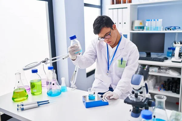 Человек Синдромом Дауна Носит Форму Ученого Измеряющую Жидкость Лаборатории — стоковое фото
