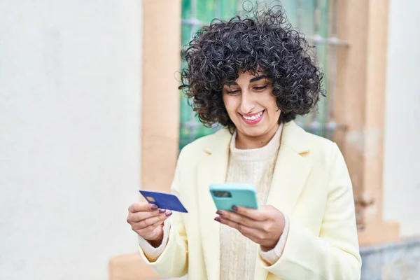 ストリートでスマートフォンやクレジットカードを使用して若い中東女性エグゼクティブ — ストック写真