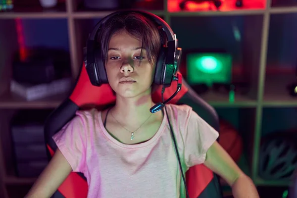 Adorable Hispanic Girl Streamer Sitting Table Serious Expression Gaming Room — Foto de Stock