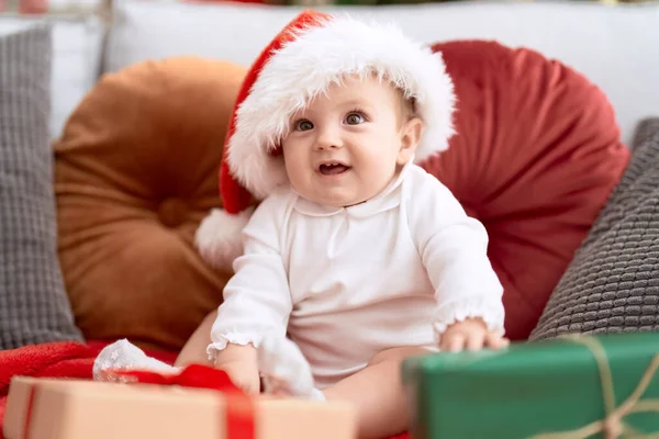 Noel Şapkası Takan Sevimli Çocuk Evde Hediyesiyle Koltukta Oturuyor — Stok fotoğraf